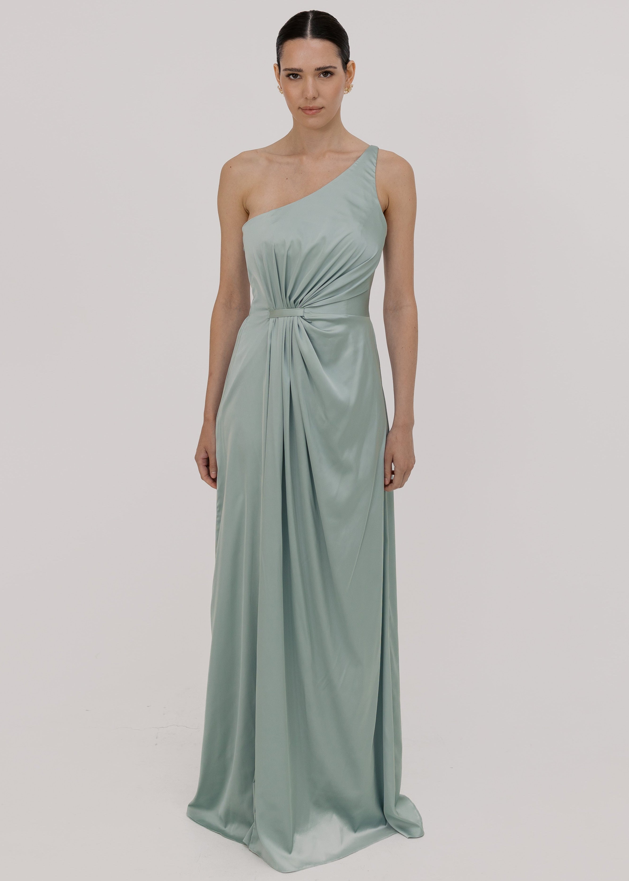 Woman wearing a green bridesmaid dress with one shoulder detail, front view by TH&TH.