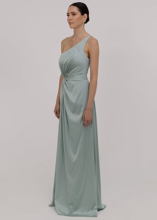 Woman wearing a green bridesmaid dress with one shoulder detail. Slight side angle by TH&TH Bridesmaids.