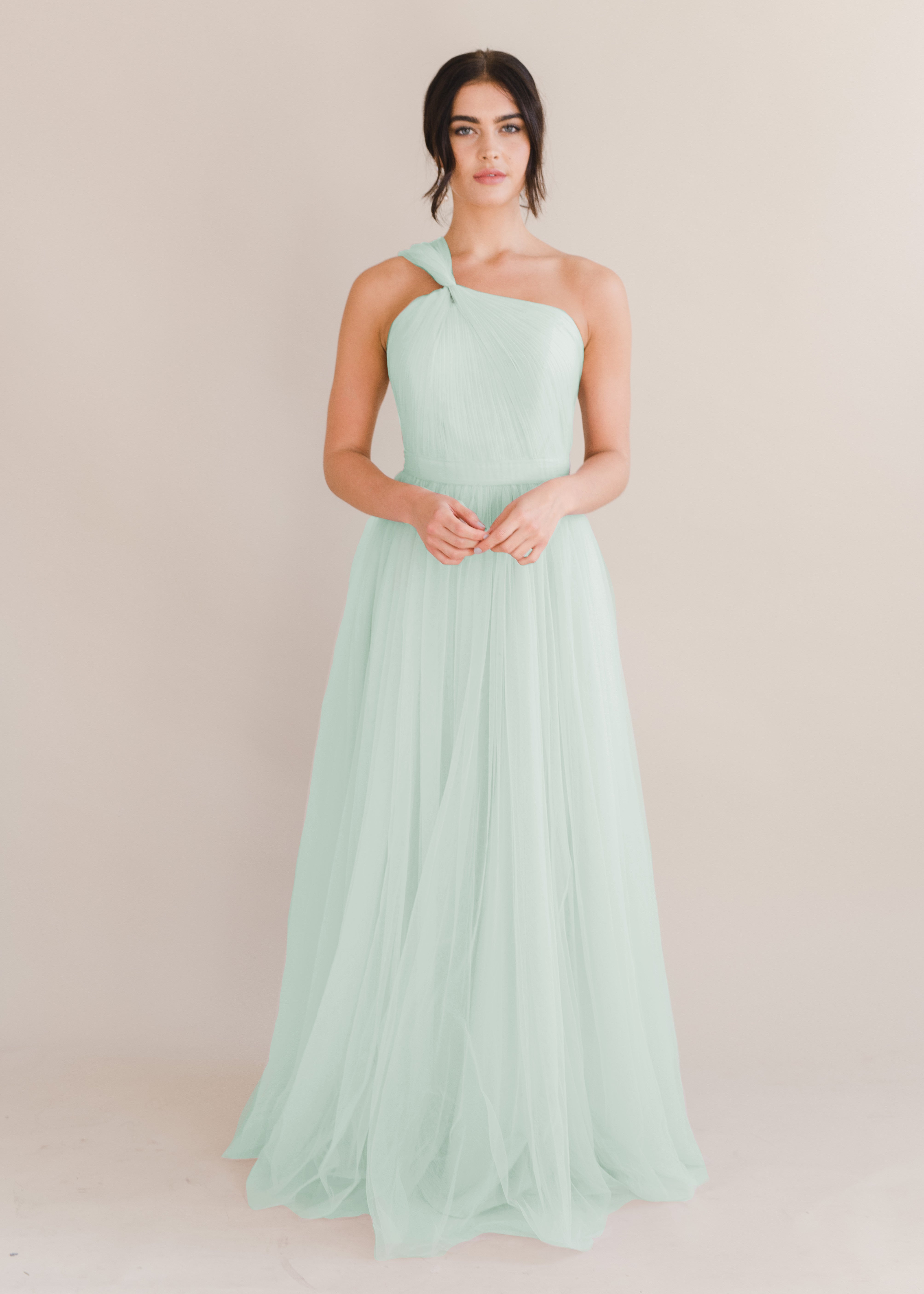 Woman model wearing green bridesmaid dress in tulle fabric by TH&TH Bridesmaids.
