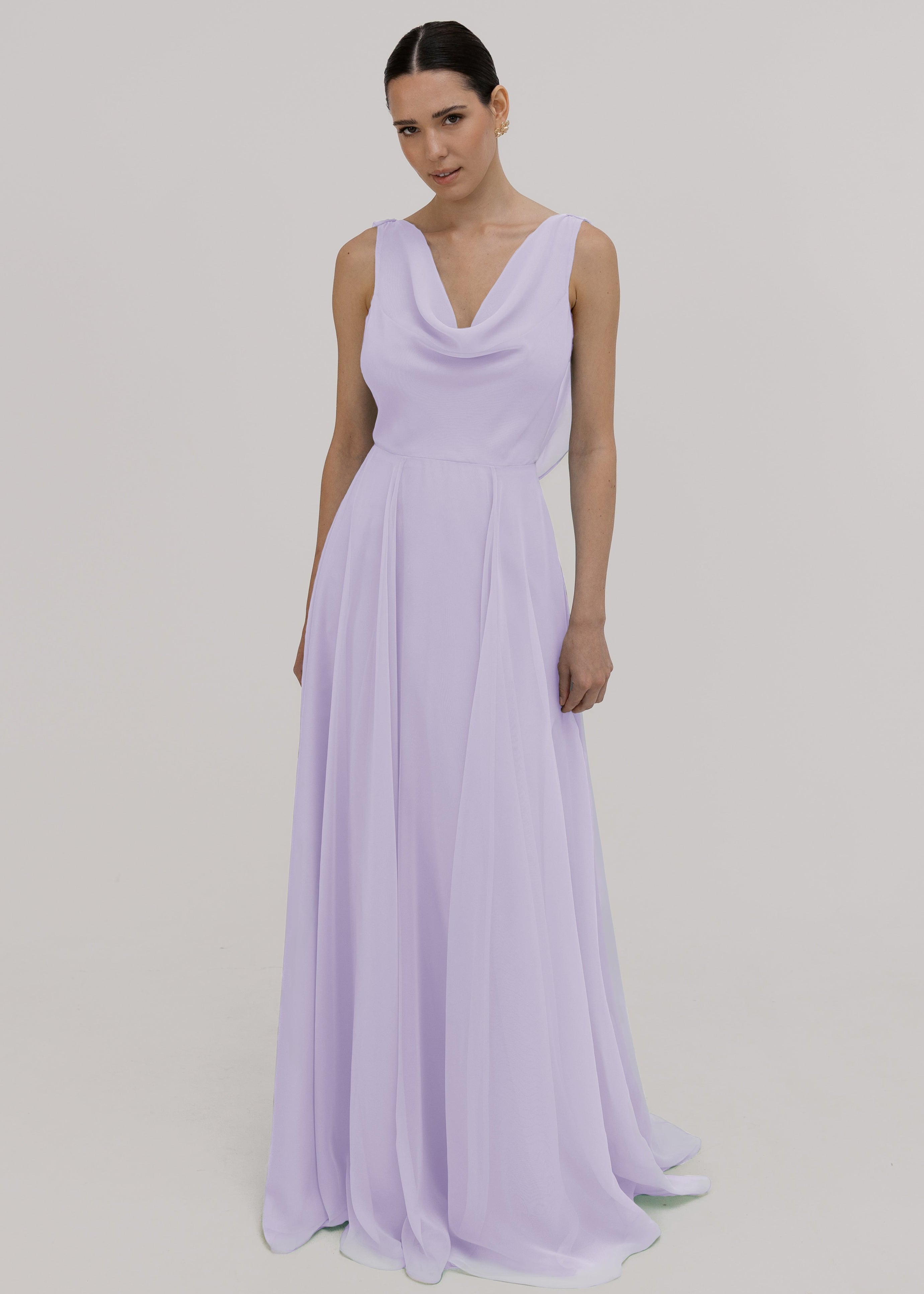 Model wearing a lilac bridesmaid dress in chiffon with cowl neckline and flowing chiffon skirt by TH&TH Bridesmaids.
