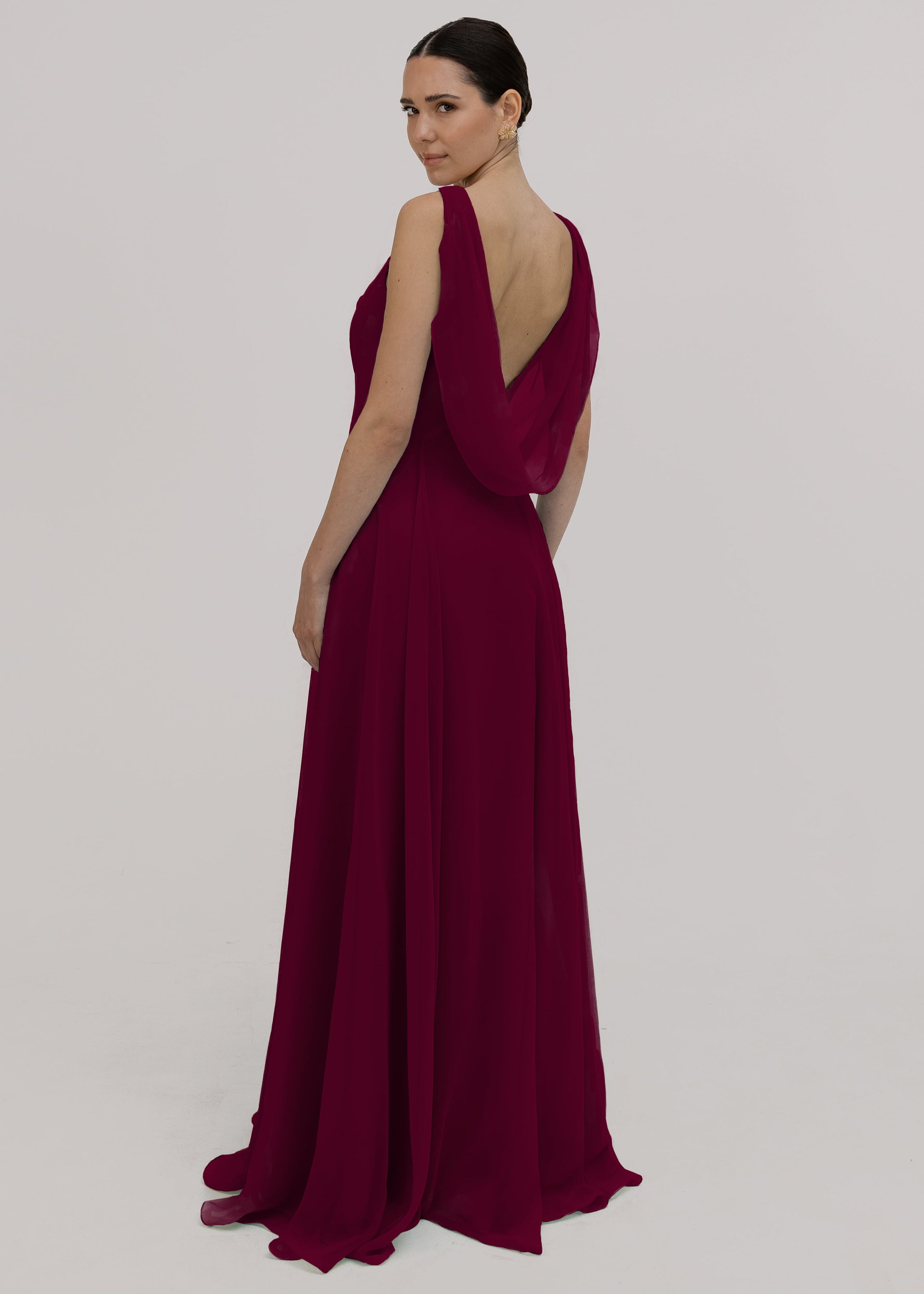 Model wearing a merlot bridesmaid dress in chiffon with cowl neckline and flowing chiffon skirt by TH&TH Bridesmaids.
