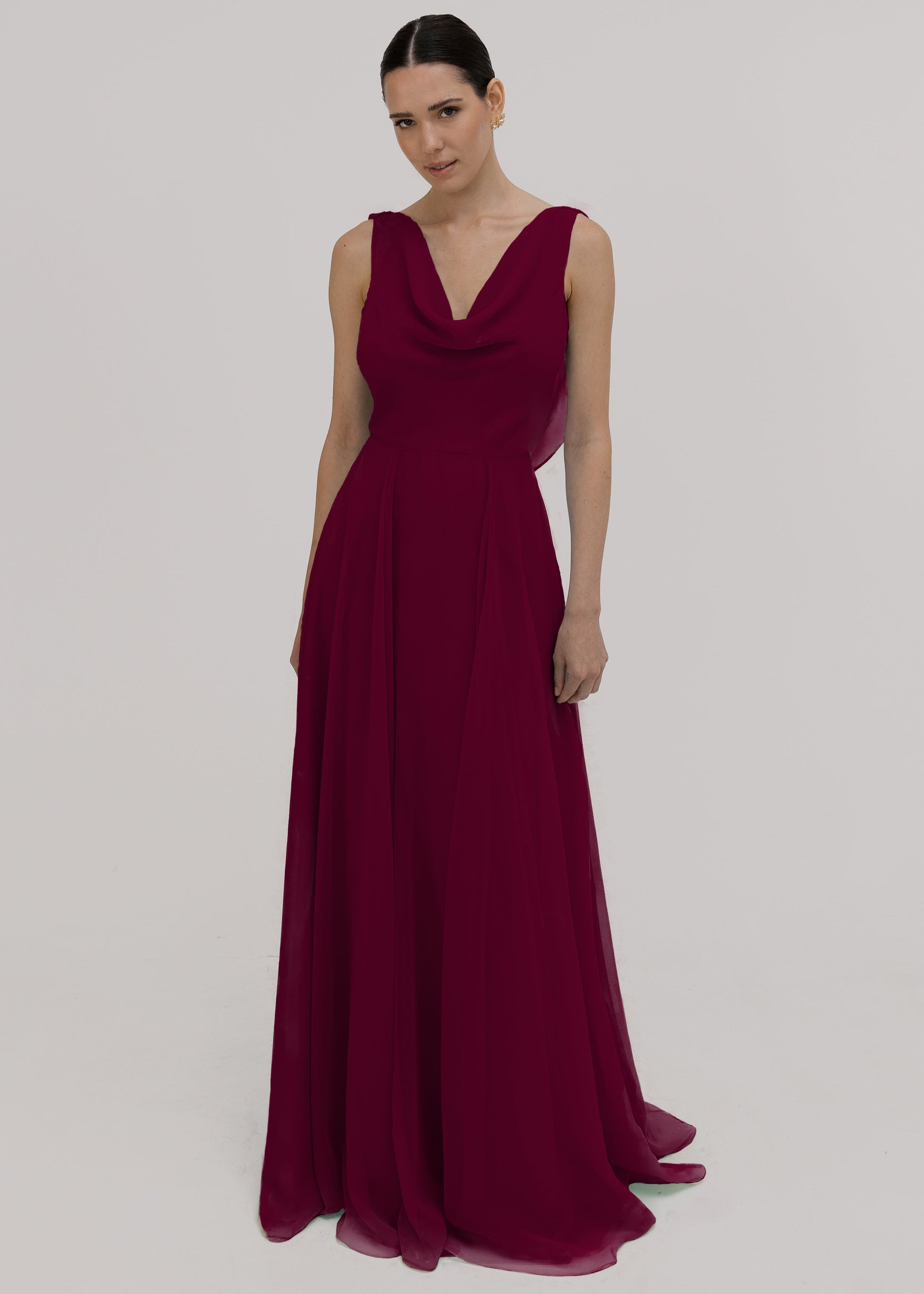 Model wearing a merlot bridesmaid dress in chiffon with cowl neckline and flowing chiffon skirt by TH&TH Bridesmaids.
