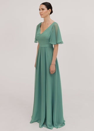 Model wears a sage green bridesmaid dress in chiffon with v front neckline, flutter sleeves and flowing chiffon skirt by TH&TH Bridesmaids. 
