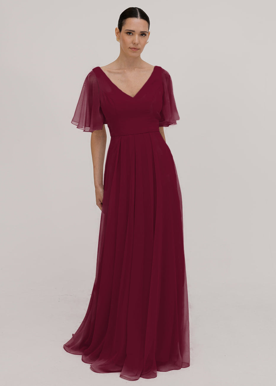 Model wears a merlot bridesmaid dress in chiffon with v front neckline, flutter sleeves and flowing chiffon skirt by TH&TH Bridesmaids. 
