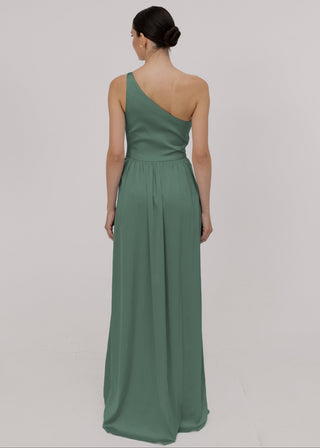 Model in a sage green one-shoulder bridesmaid gown with gathers at the skirt waist by TH&TH Bridesmaids.