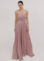 Model wearing a floor length pink satin bridesmaid dress with V back and spaghetti straps by TH&TH Bridesmaids.