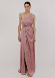 Model wearing a floor length pink satin bridesmaid dress with one shoulder and slit in skirt by TH&TH Bridesmaids.
