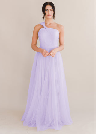 A woman wearing a lilac bridesmaid dress with one shoulder strap on a white background by TH&TH Bridesmaids. 