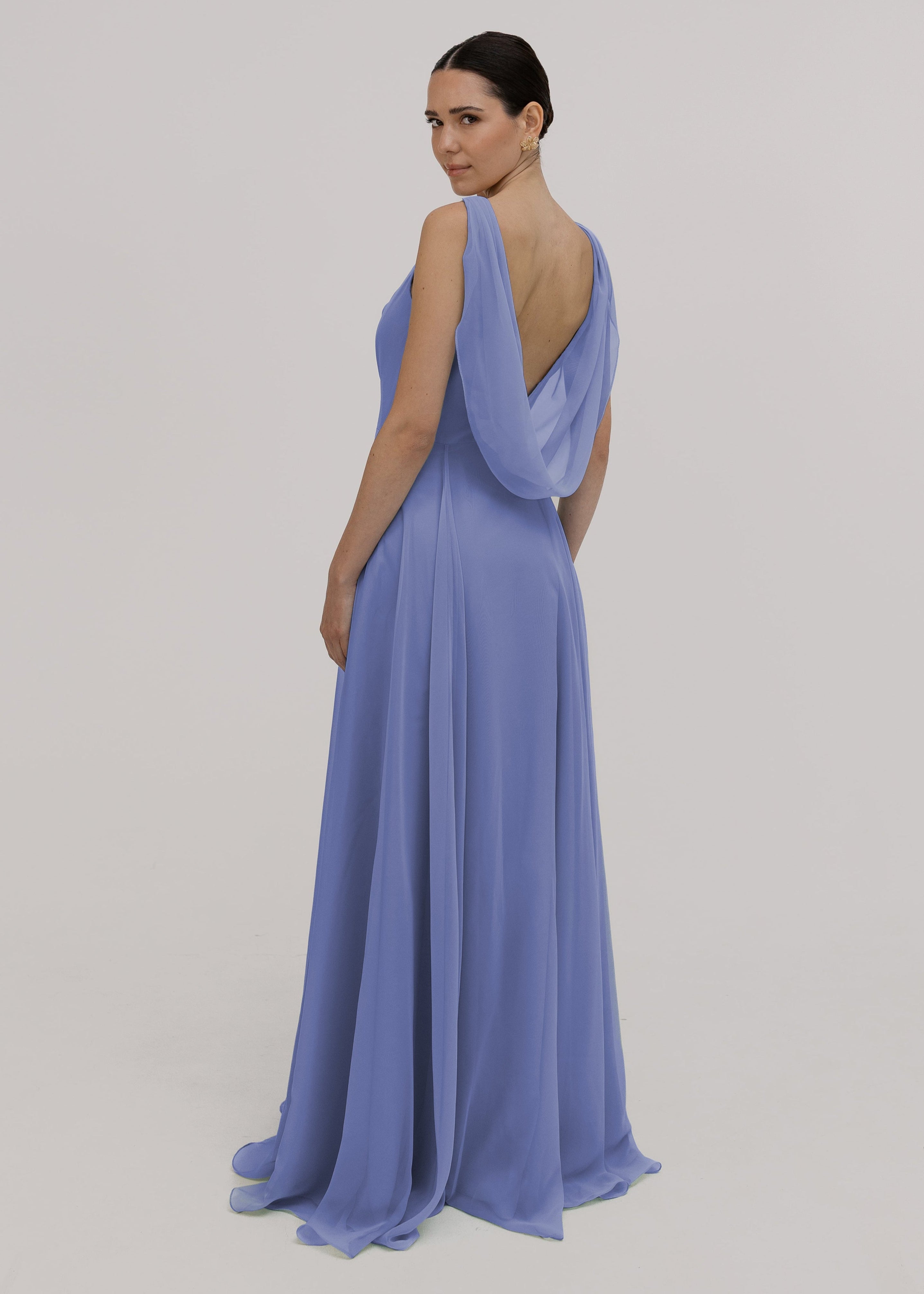 Woman wearing a long blue bridesmaid dress with cowl neck and cowl back in french blue chiffon.