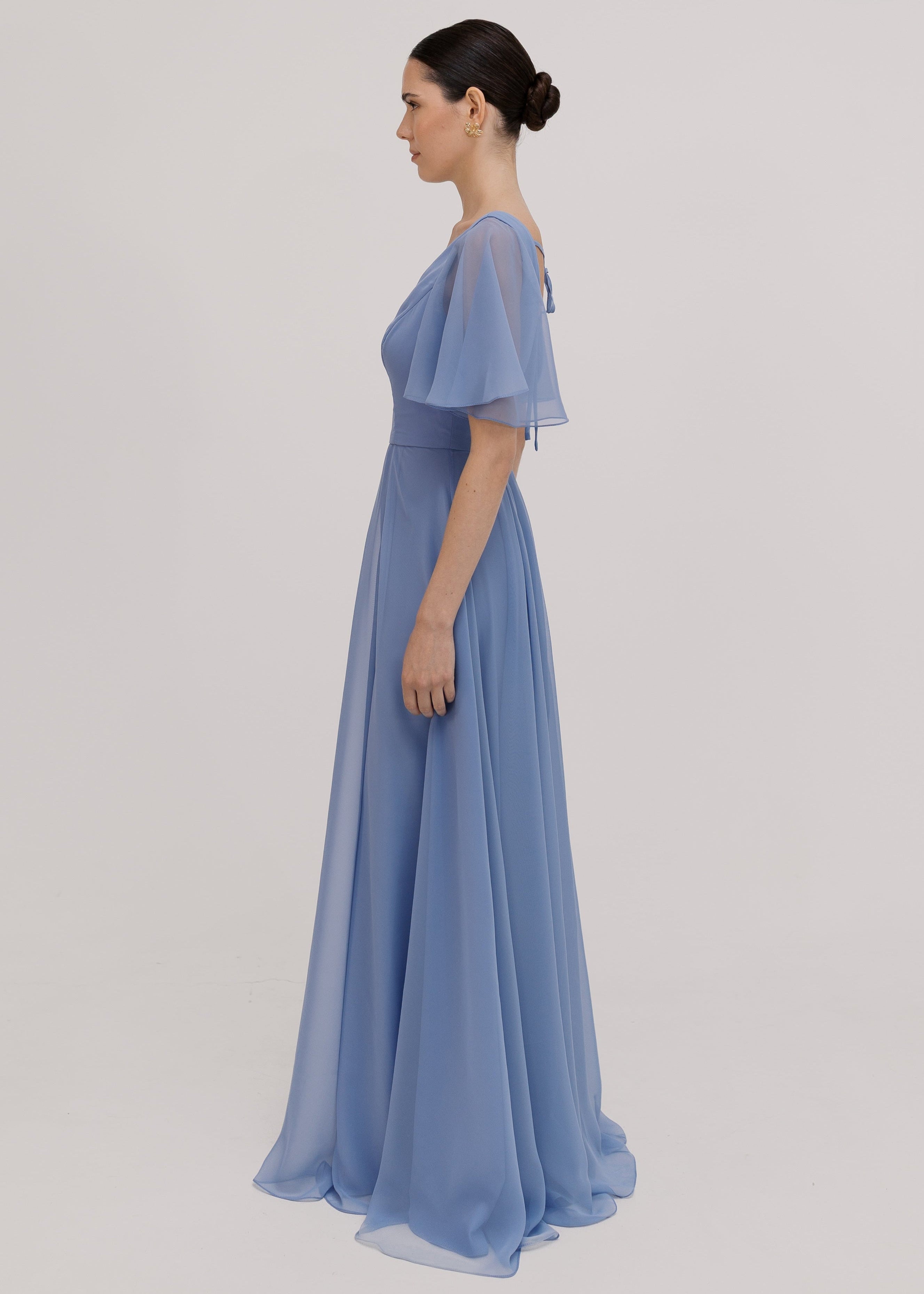 Woman wearing a long blue dress with short sleeves, V neck and a line skirt in french blue chiffon.