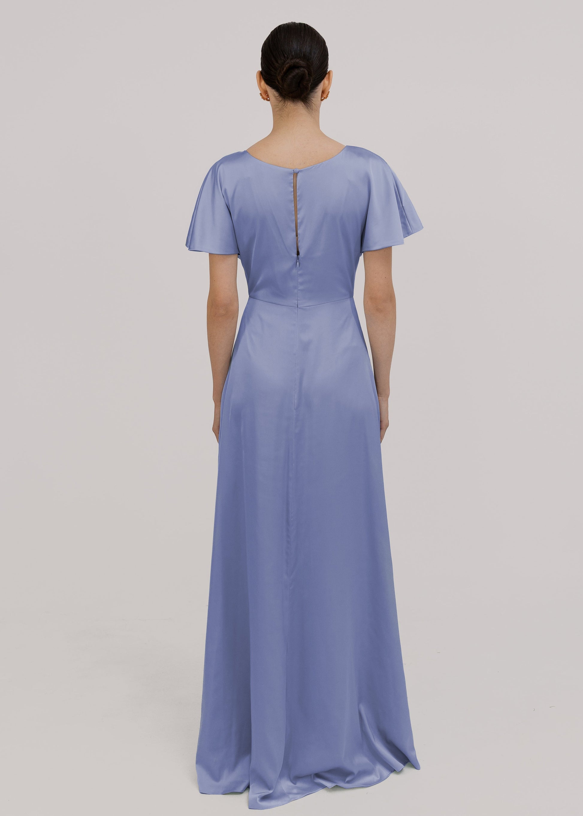 Woman wearing a long blue bridesmaid dress with sleeves, twist knot and bra friendly high back, in french blue satin.