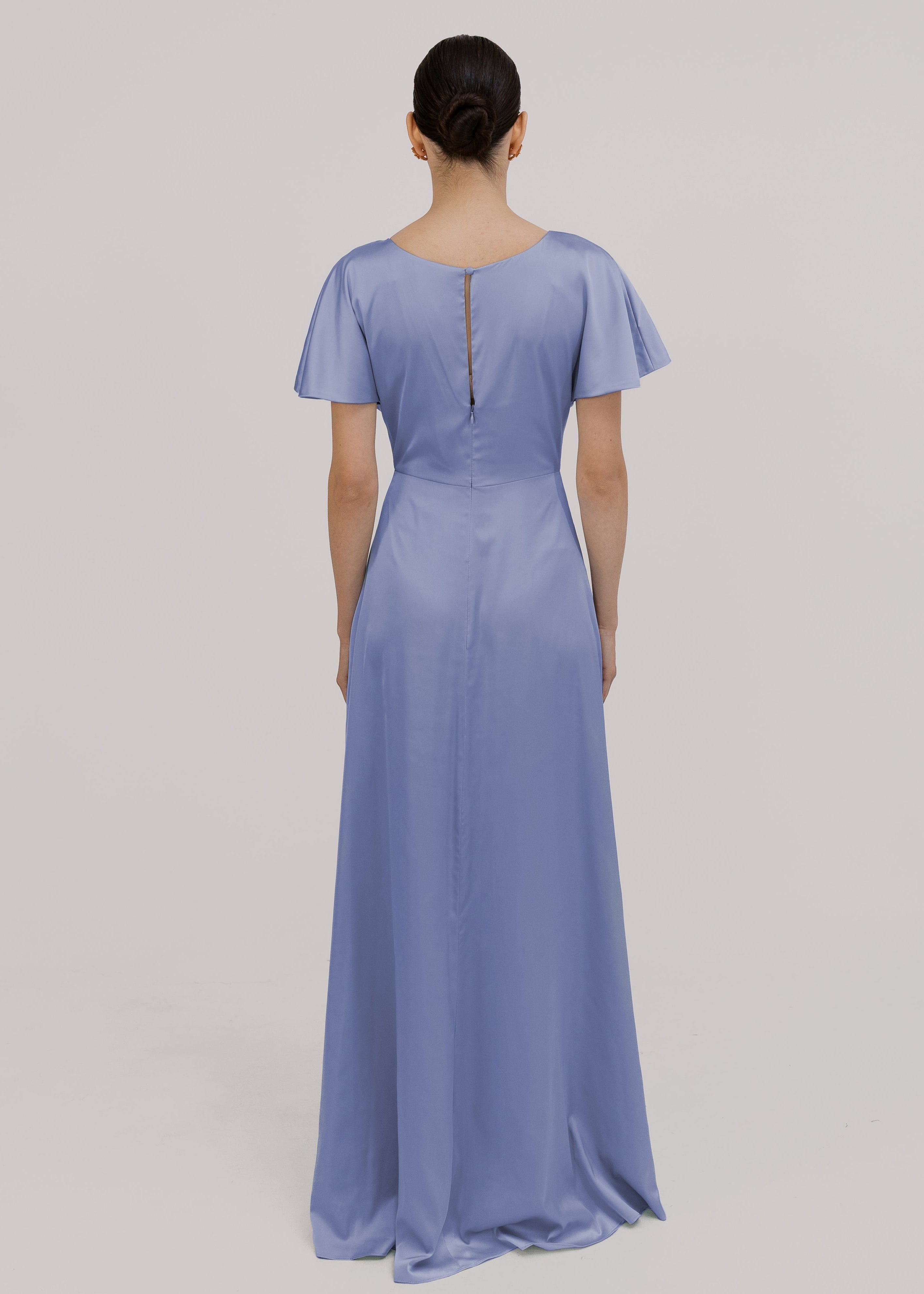 Woman wearing a long blue bridesmaid dress with sleeves, twist knot and bra friendly high back, in french blue satin.
