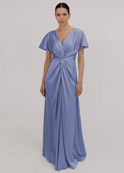Woman wearing a long blue bridesmaid dress with sleeves, twist knot and bra friendly high back, in french blue satin.