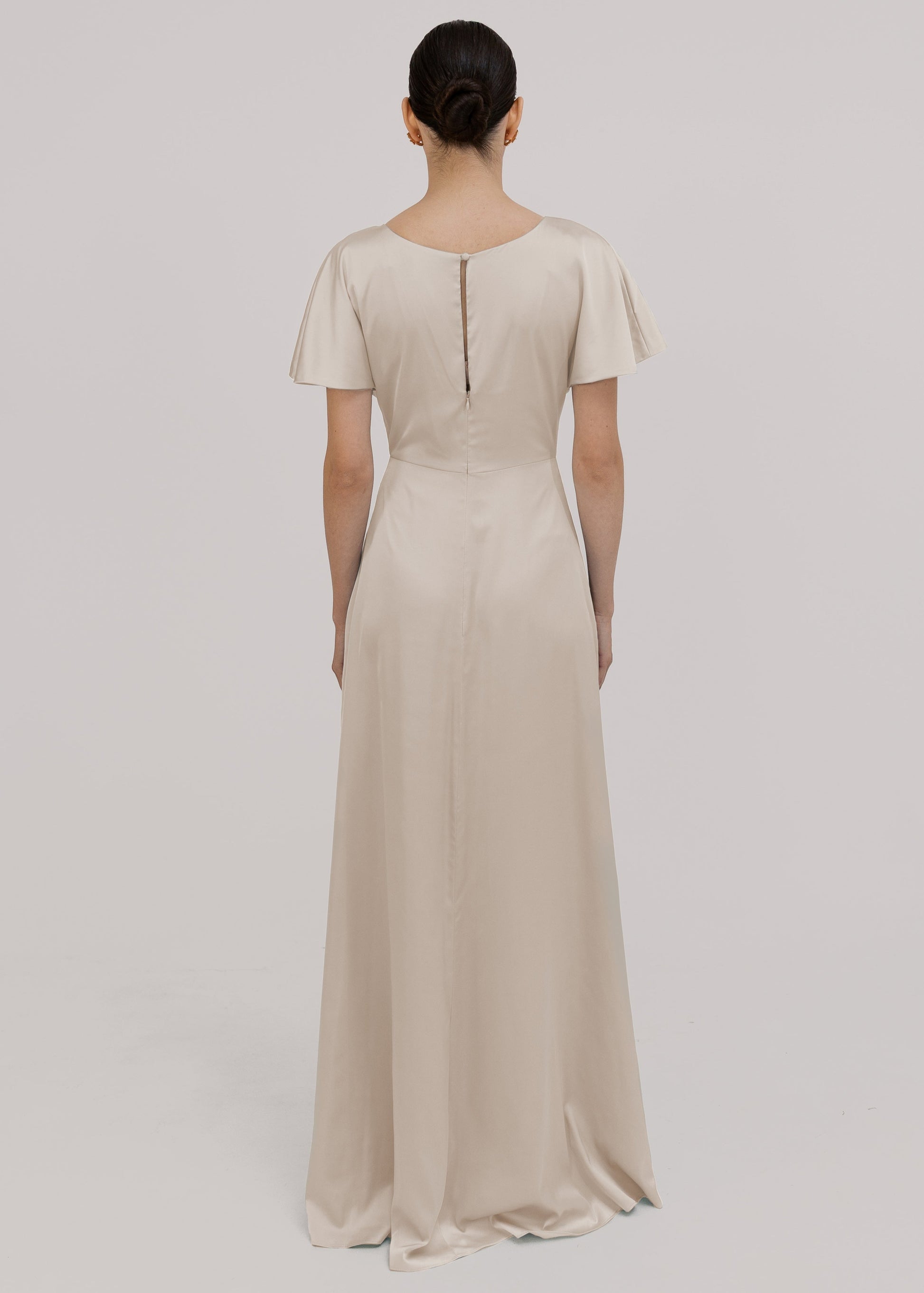 Woman wearing an oyster bridesmaid dress with short sleeves by TH&TH.
