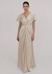Woman wearing an oyster satin bridesmaid dress with twist knot detail by TH&TH.