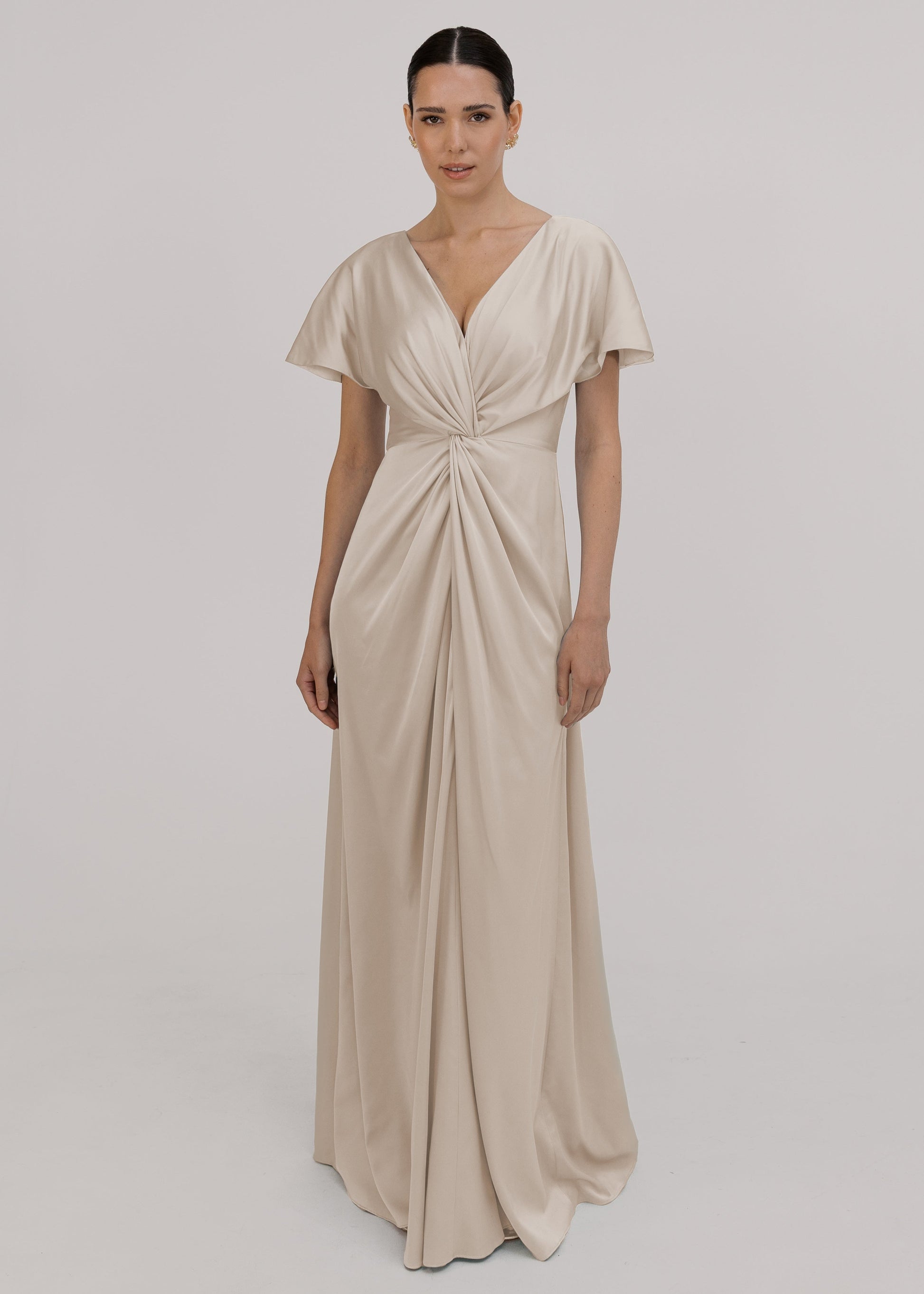 Woman wearing an oyster satin bridesmaid dress with twist knot detail by TH&TH.