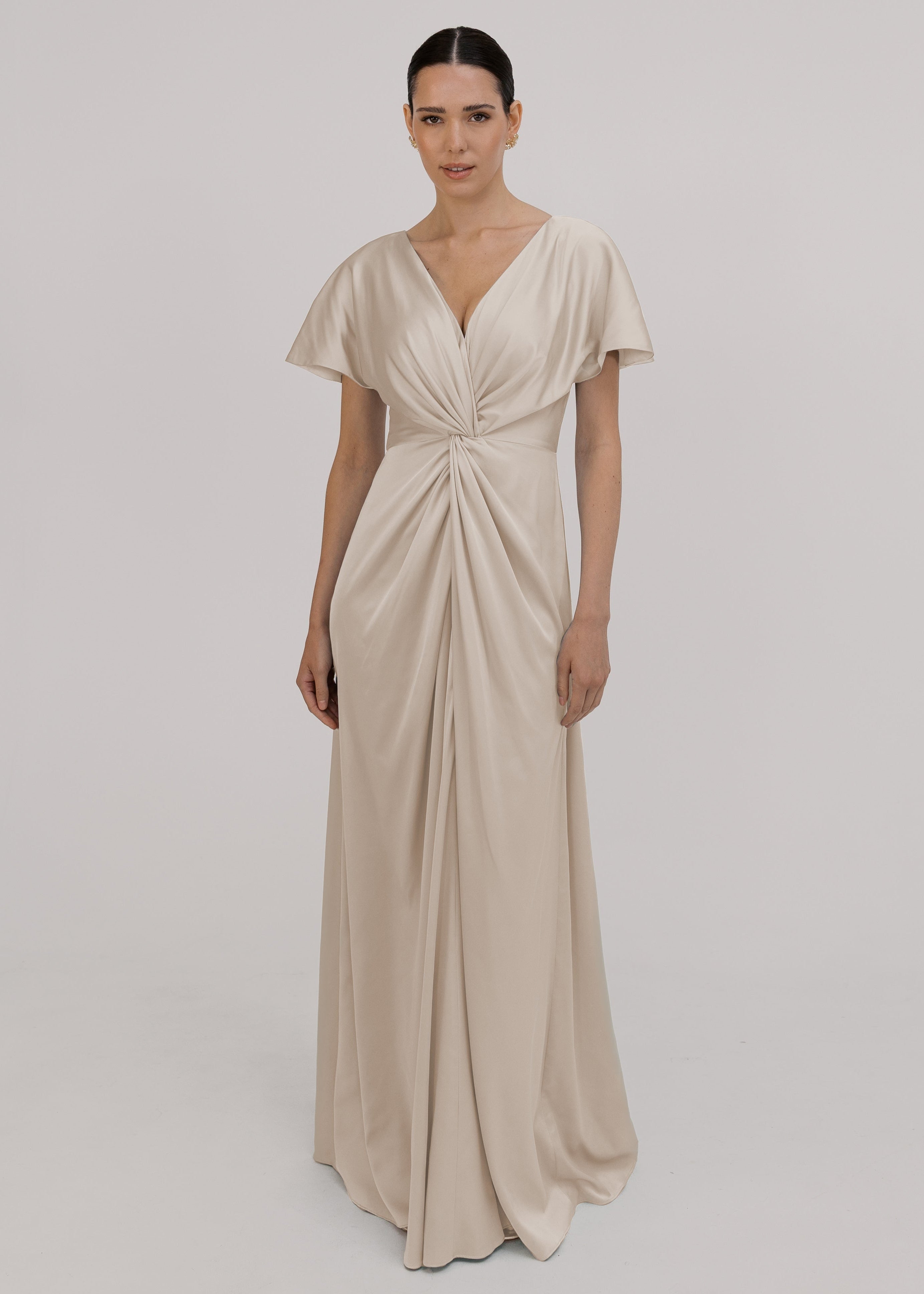 Woman wearing an oyster satin bridesmaid dress with twist knot detail by TH&TH.