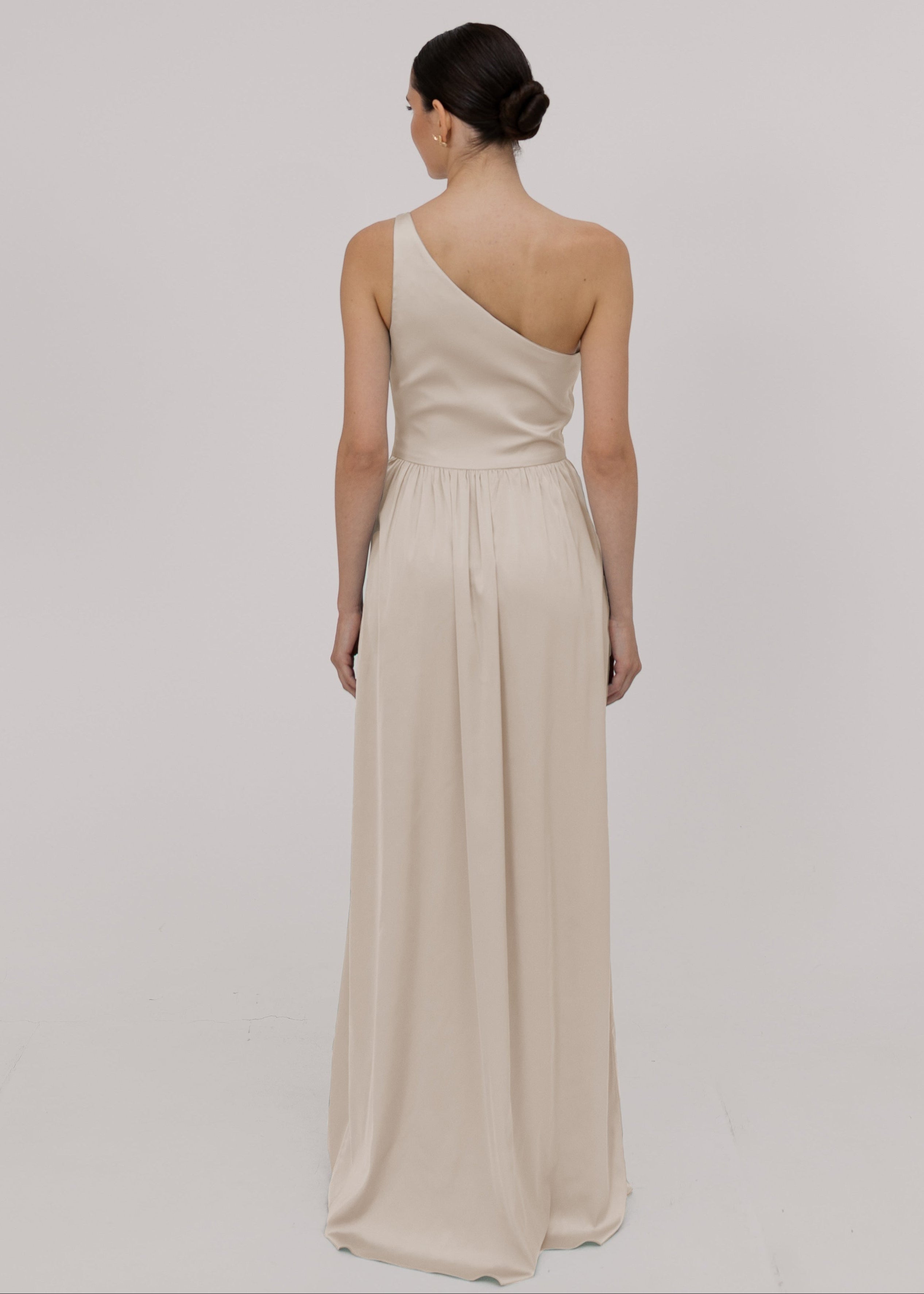 Woman wearing an oyster one-shoulder bridesmaid dress by TH&TH.