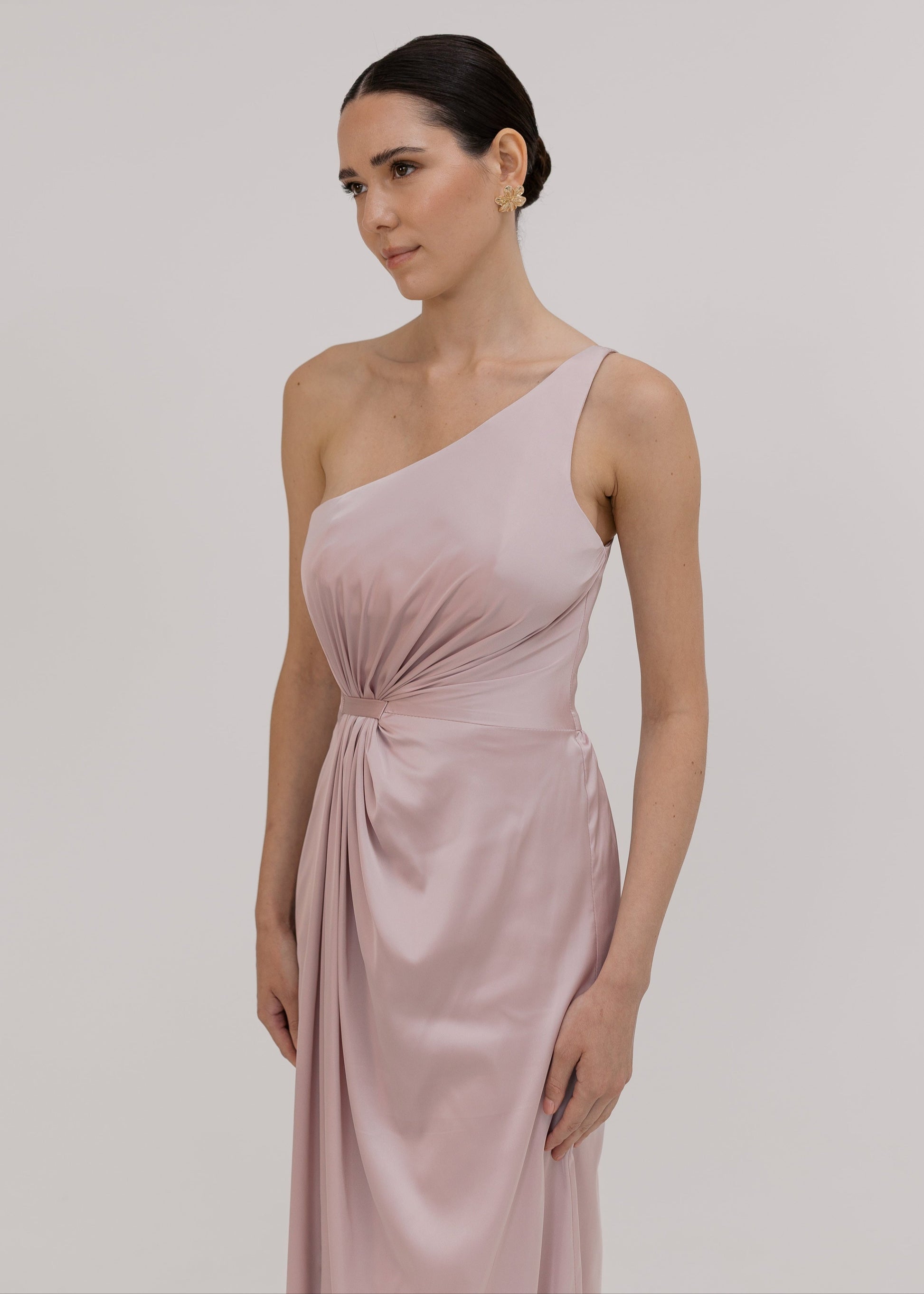 Woman wearing a one-shoulder pink bridesmaid dress by TH&TH.