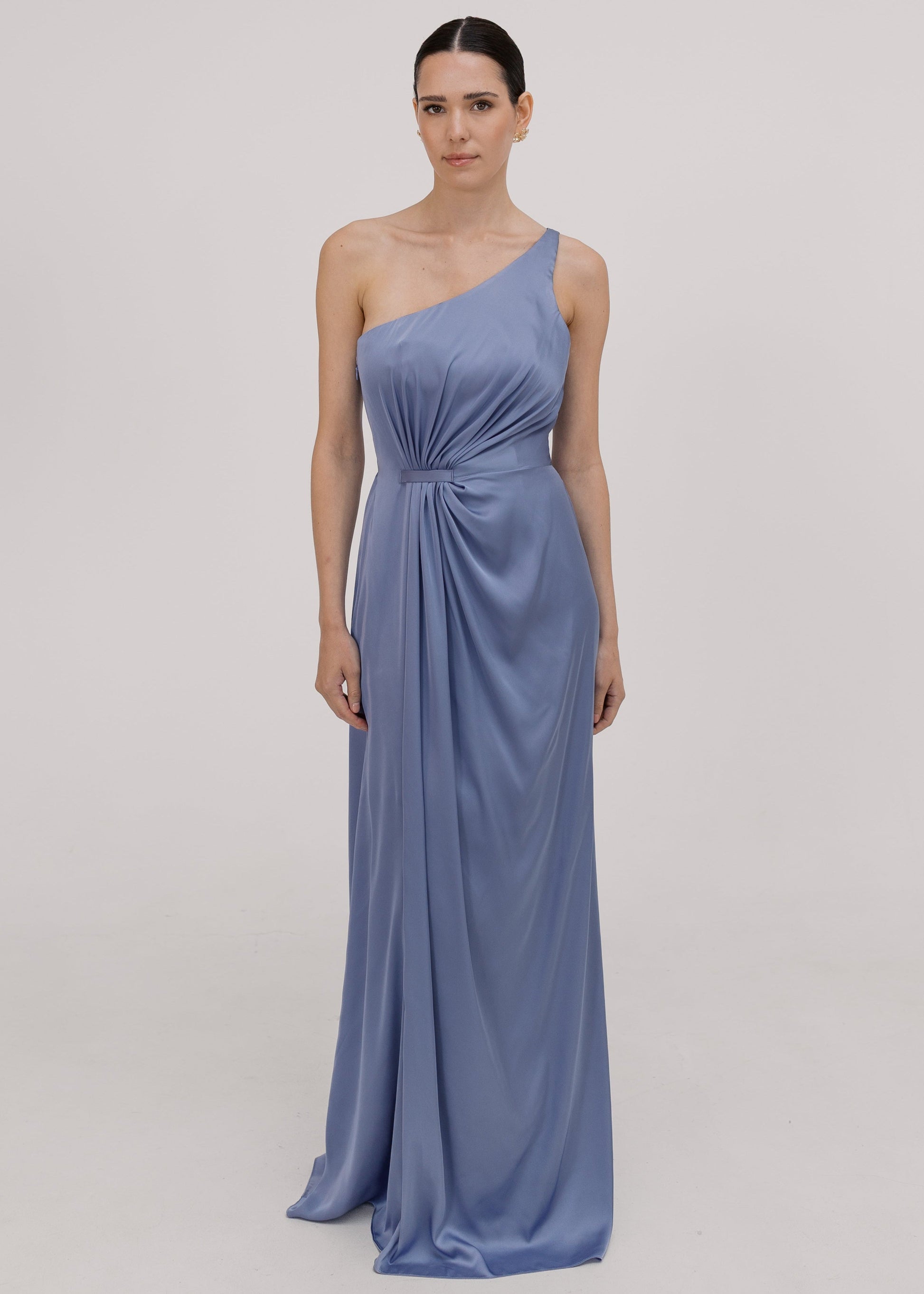 Woman wearing a long blue bridesmaid dress with one shoulder, in french blue satin.