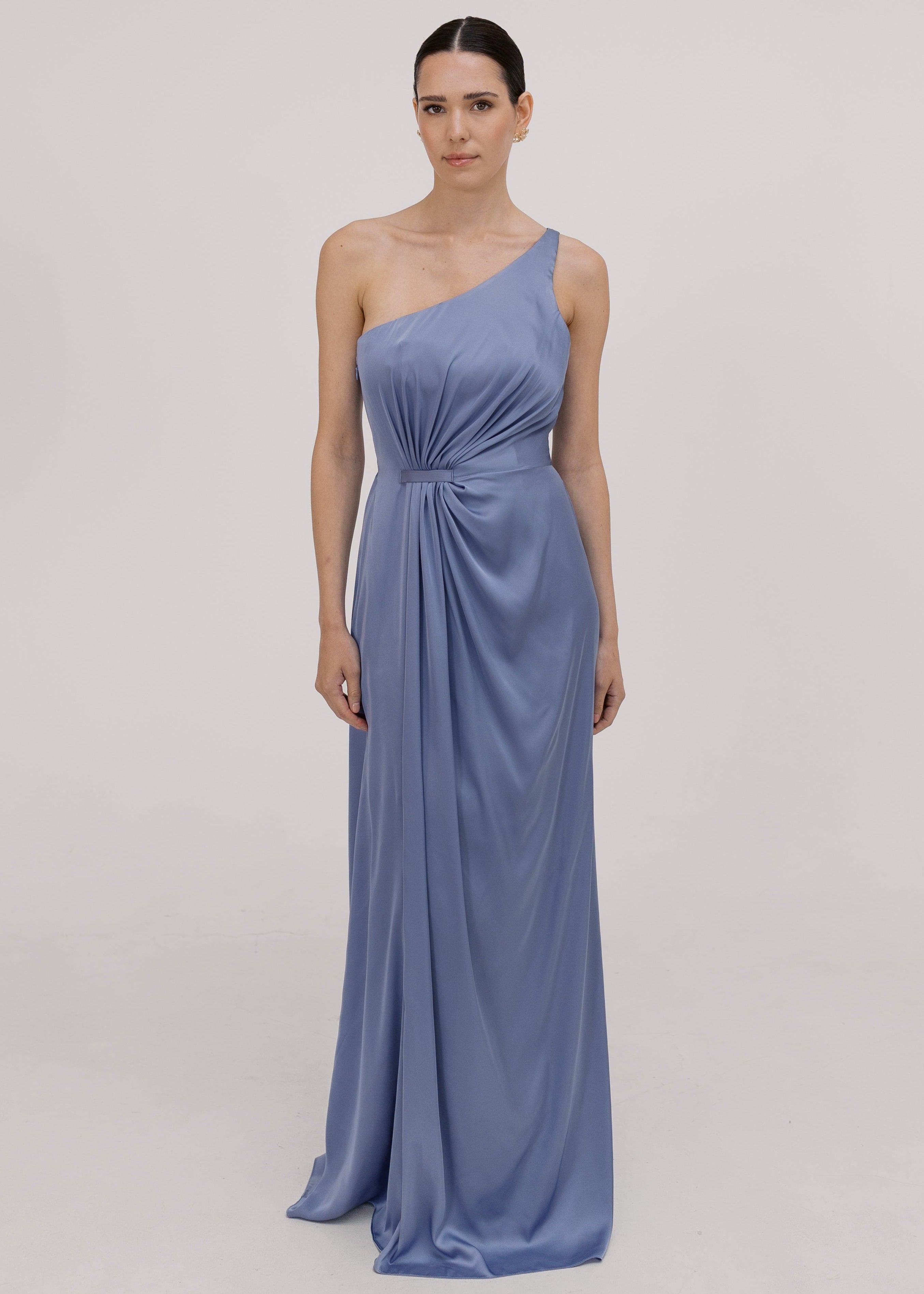Woman wearing a long blue bridesmaid dress with one shoulder, in french blue satin.