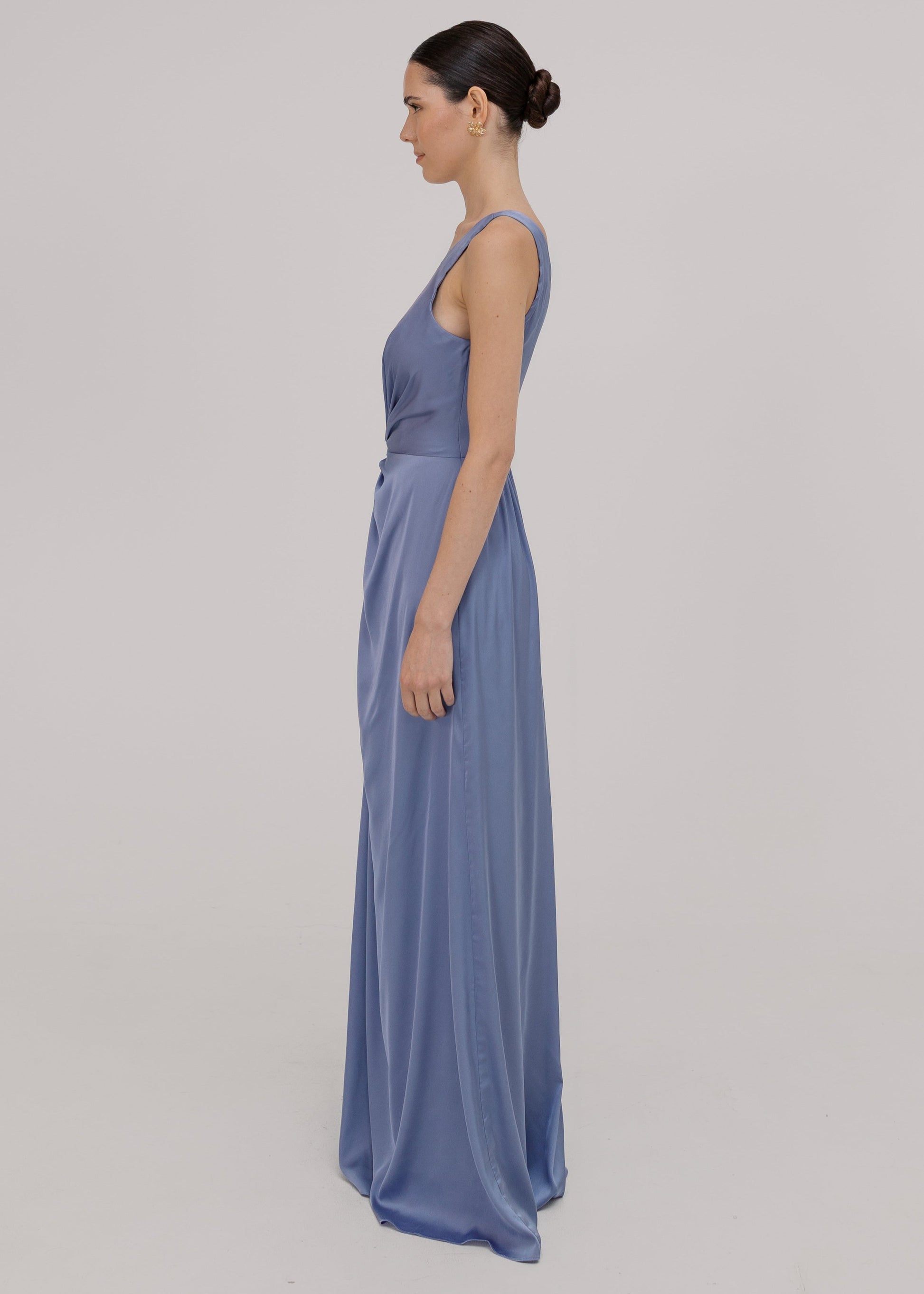 Woman wearing a long blue bridesmaid dress with one shoulder, in french blue satin.