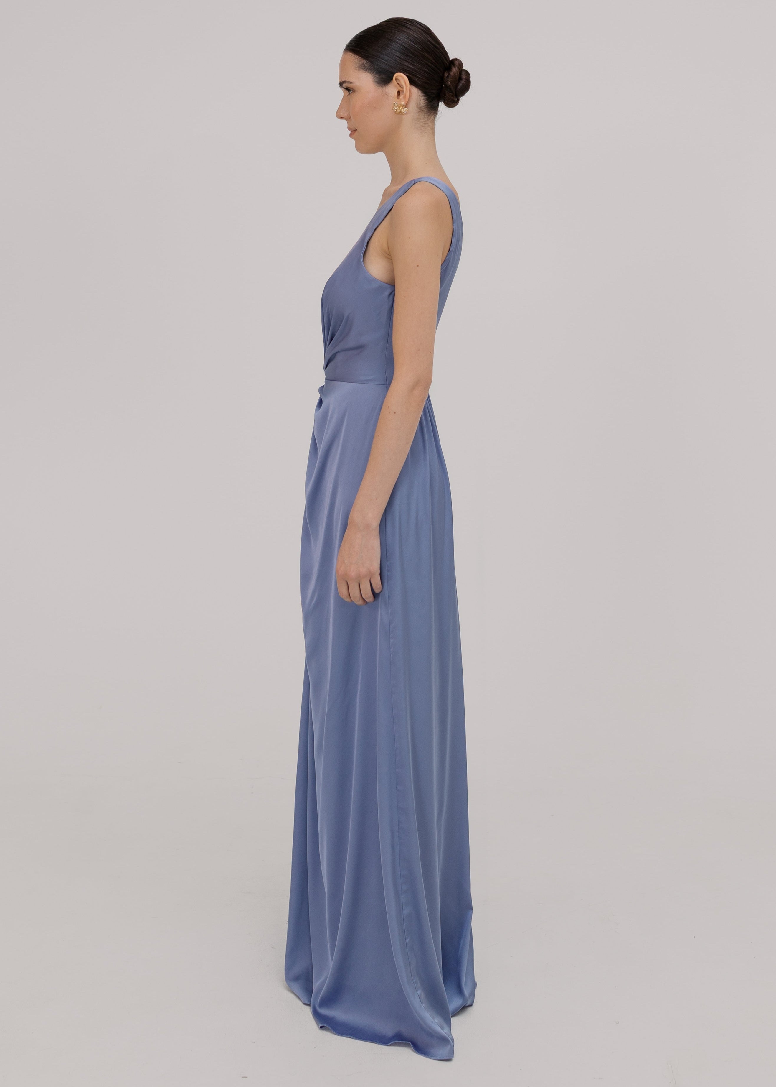 Woman wearing a long blue bridesmaid dress with one shoulder, in french blue satin.