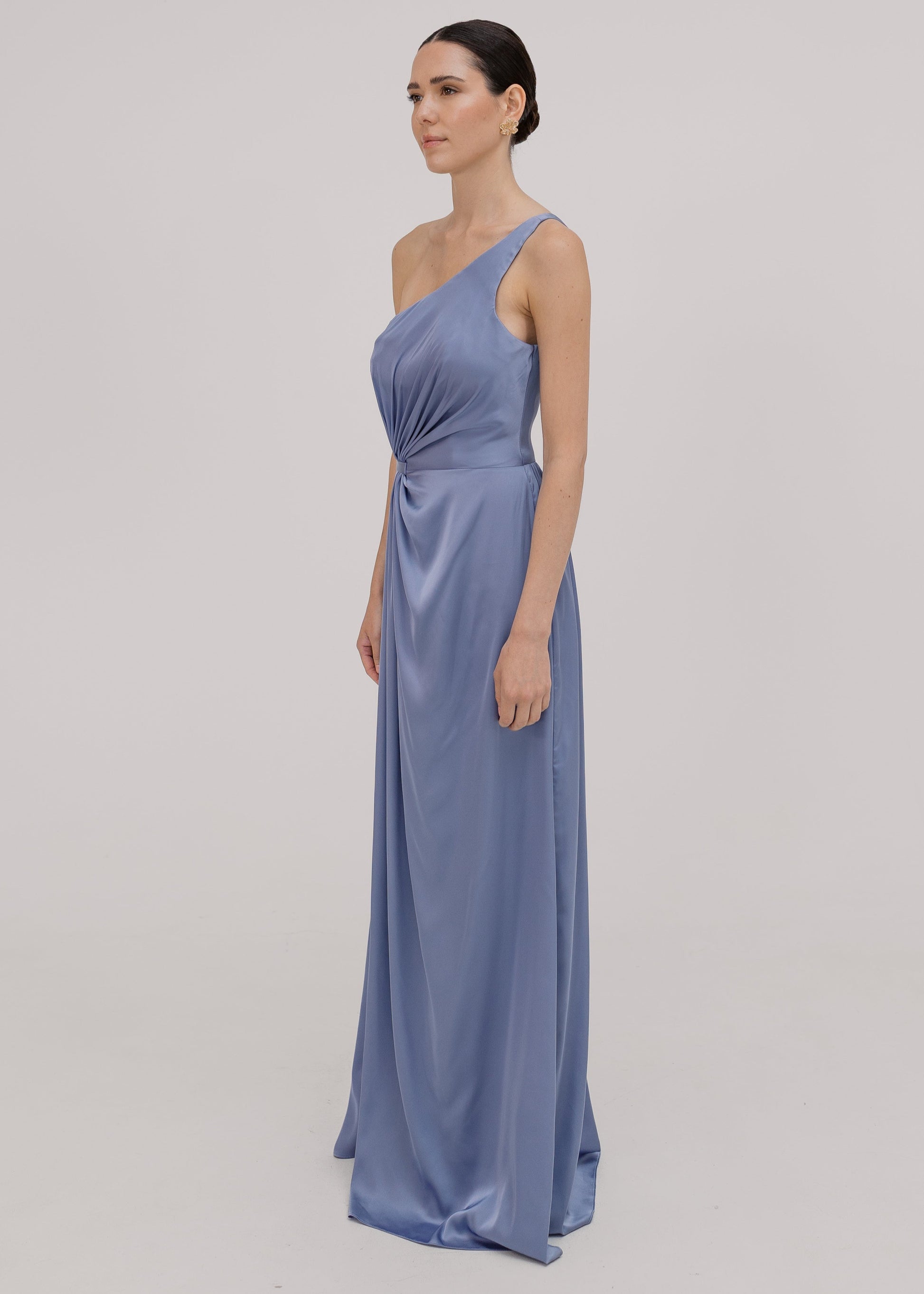Woman wearing a long blue bridesmaid dress with one shoulder, in french blue satin.