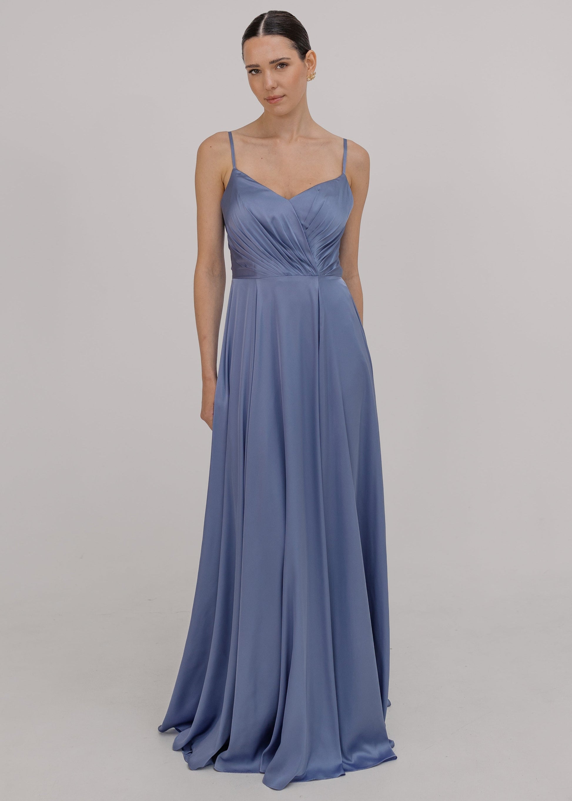 Woman wearing a long blue bridesmaid dress with cami bodice, V neck and a line skirt in french blue satin.