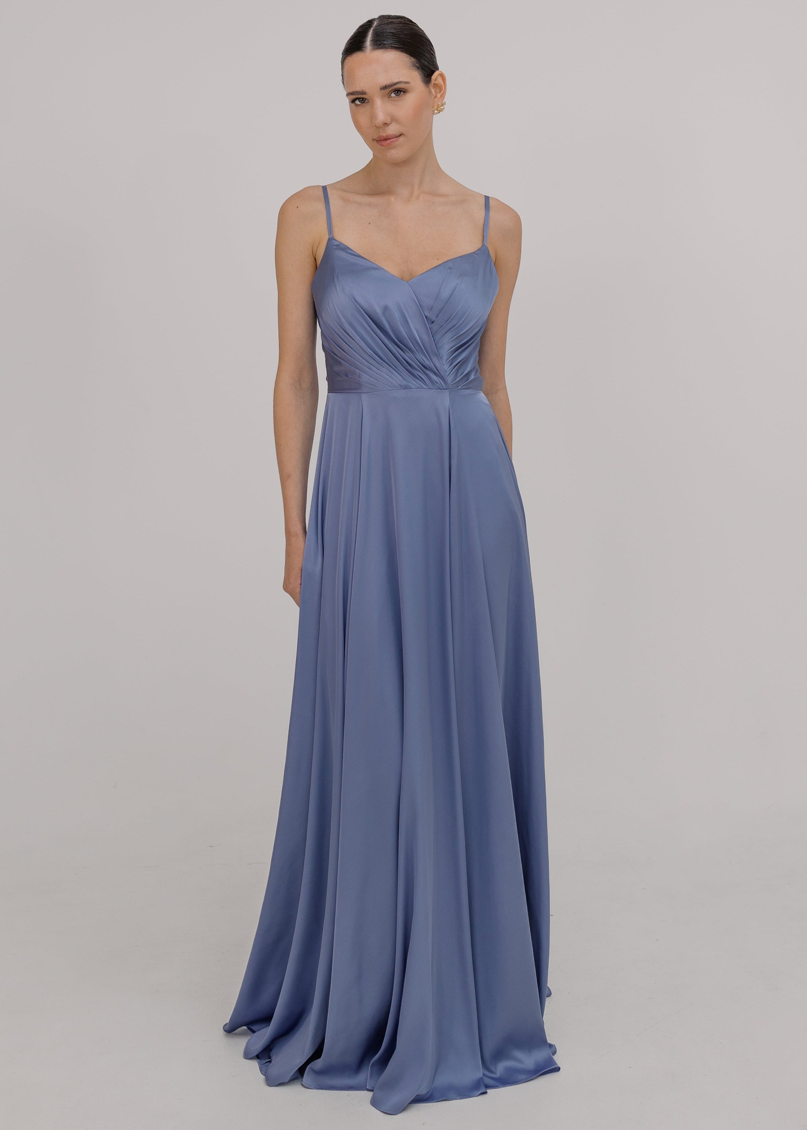 Woman wearing a long blue bridesmaid dress with cami bodice, V neck and a line skirt in french blue satin.