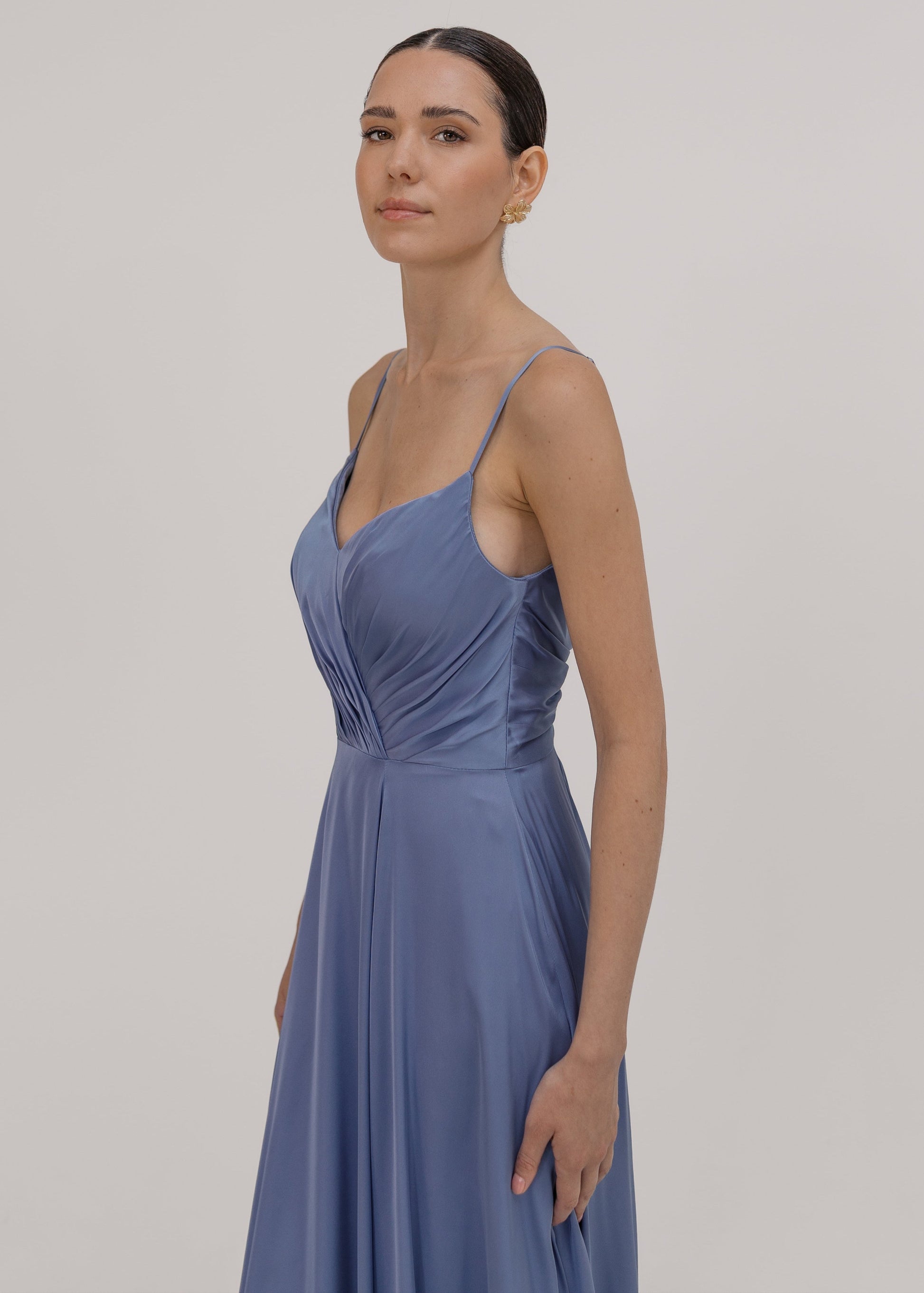 Woman wearing a long blue bridesmaid dress with cami bodice, V neck and a line skirt in french blue satin.