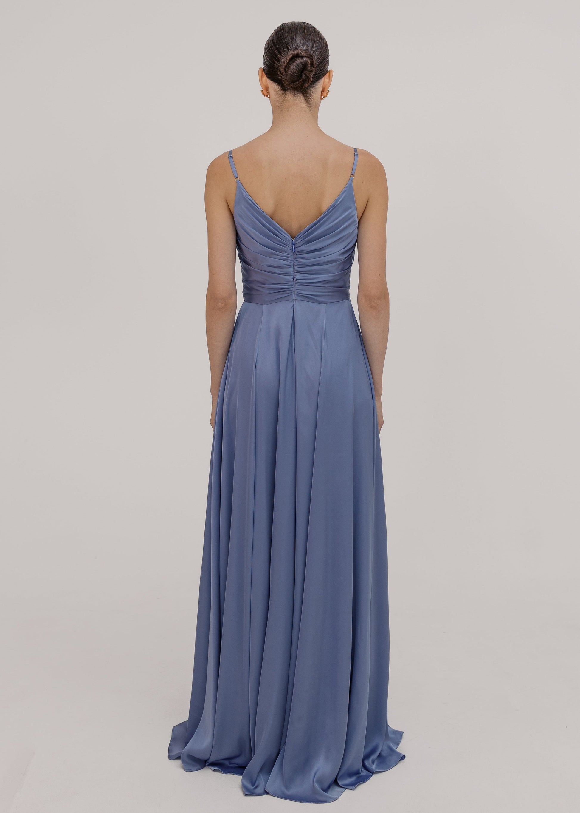 Woman wearing a long blue bridesmaid dress with cami bodice, V neck and a line skirt in french blue satin.