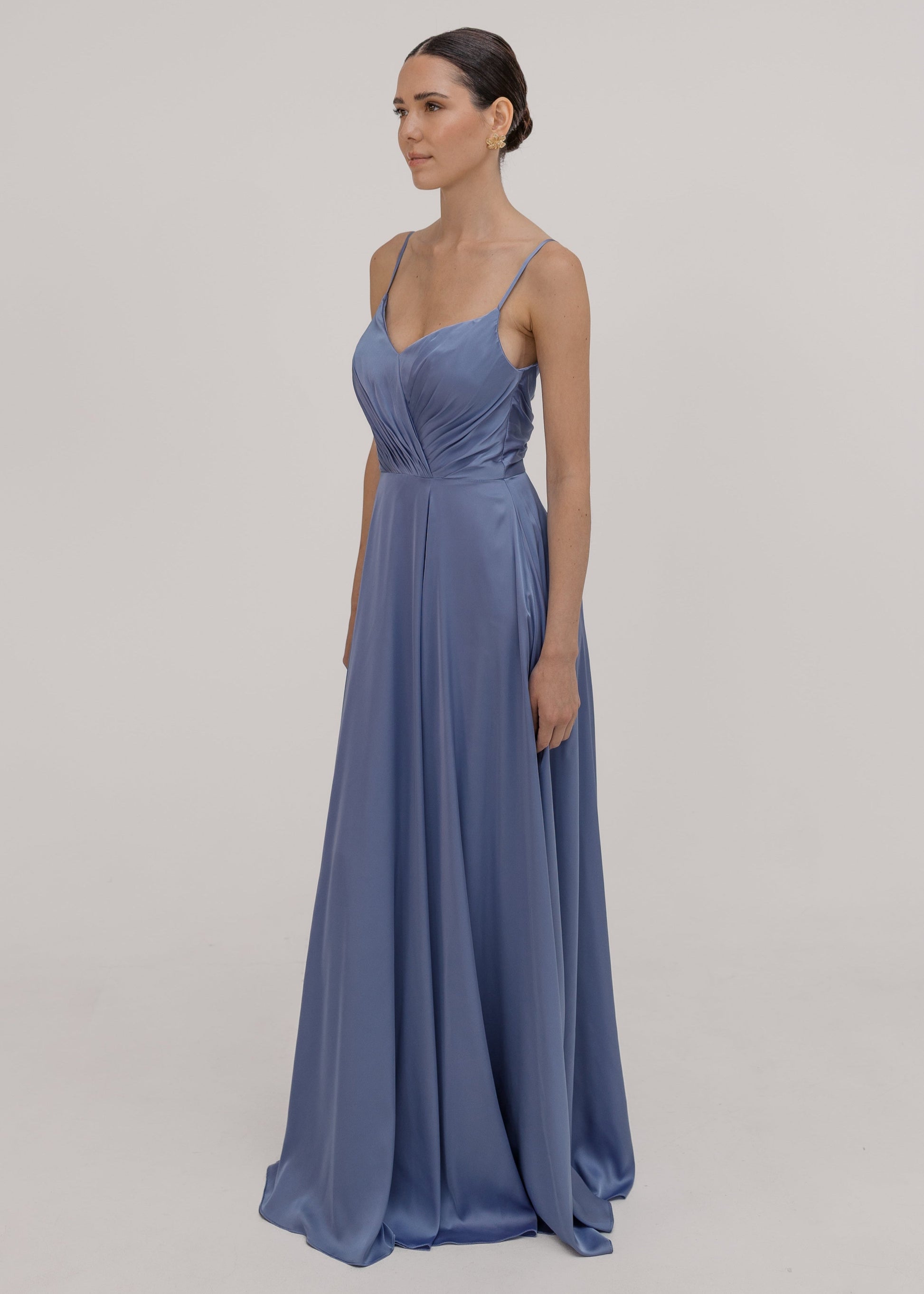 Woman wearing a long blue bridesmaid dress with cami bodice, V neck and a line skirt in french blue satin.