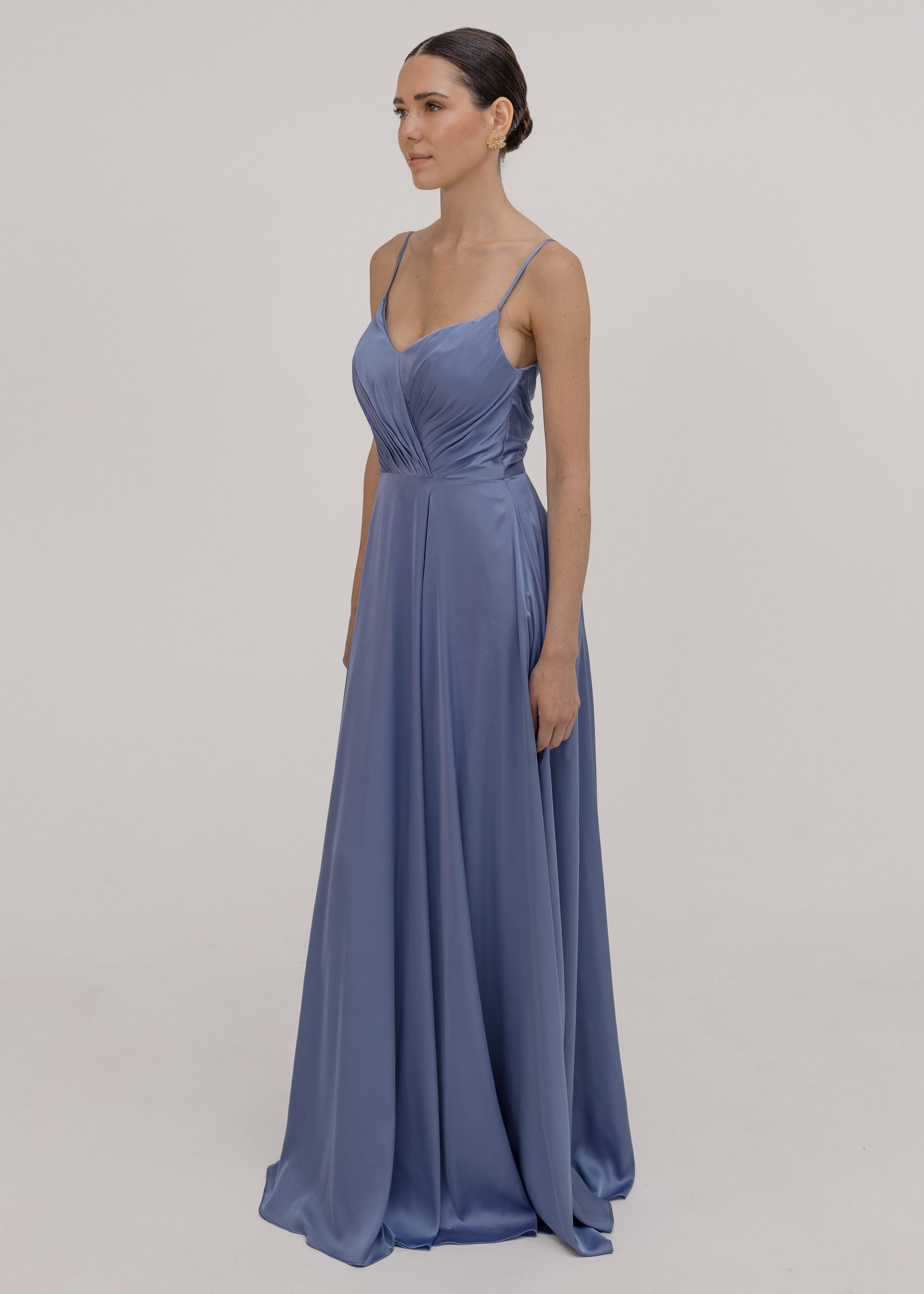 Woman wearing a long blue bridesmaid dress with cami bodice, V neck and a line skirt in french blue satin.