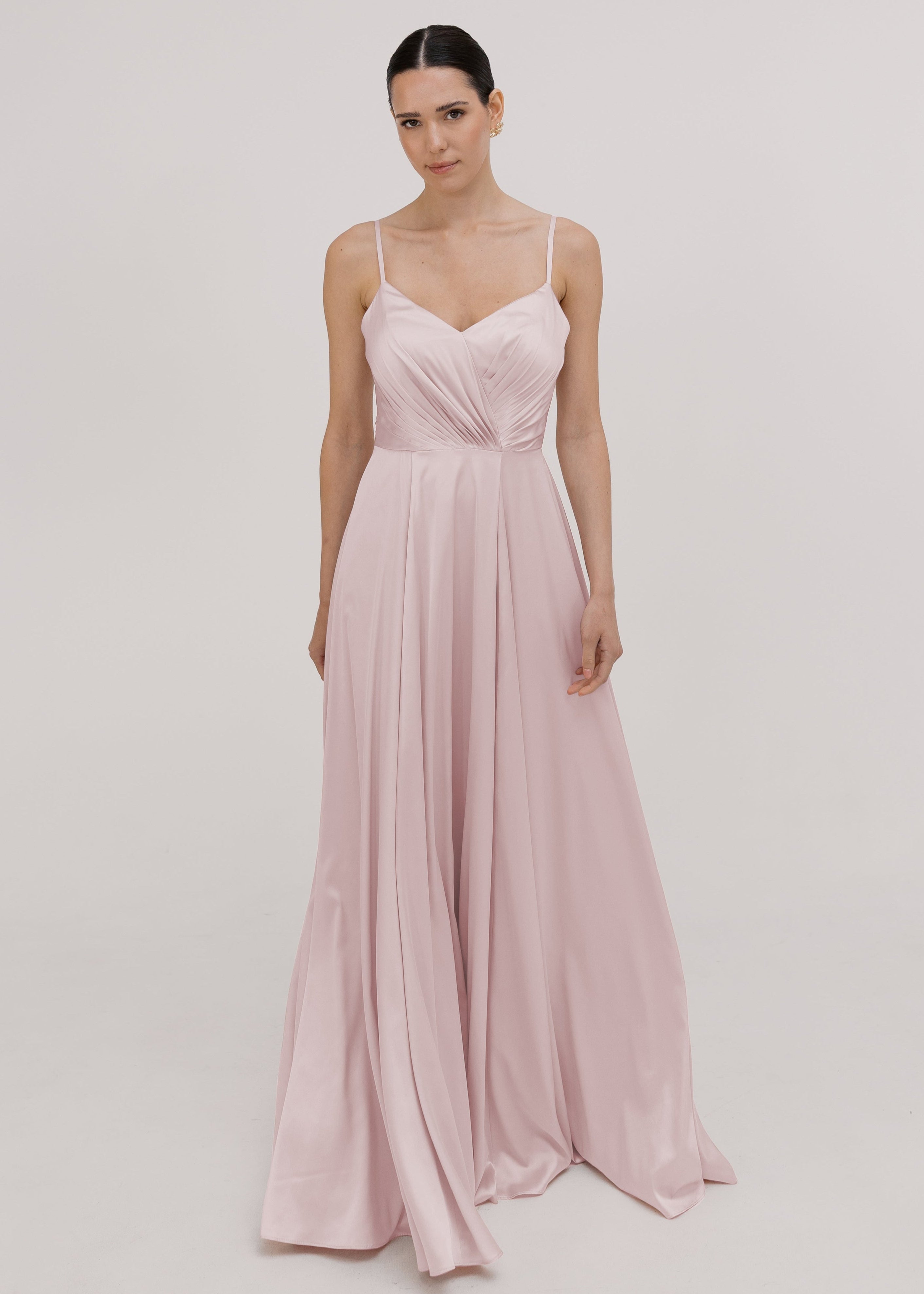 Woman wearing a smoked blush pink satin flowing  bridesmaid dress by TH&TH.