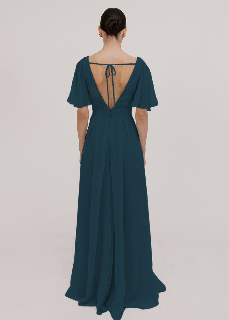 Woman wearing a long emerald dawn green bridesmaid dress with sleeves v neck and full skirt in chiffon.