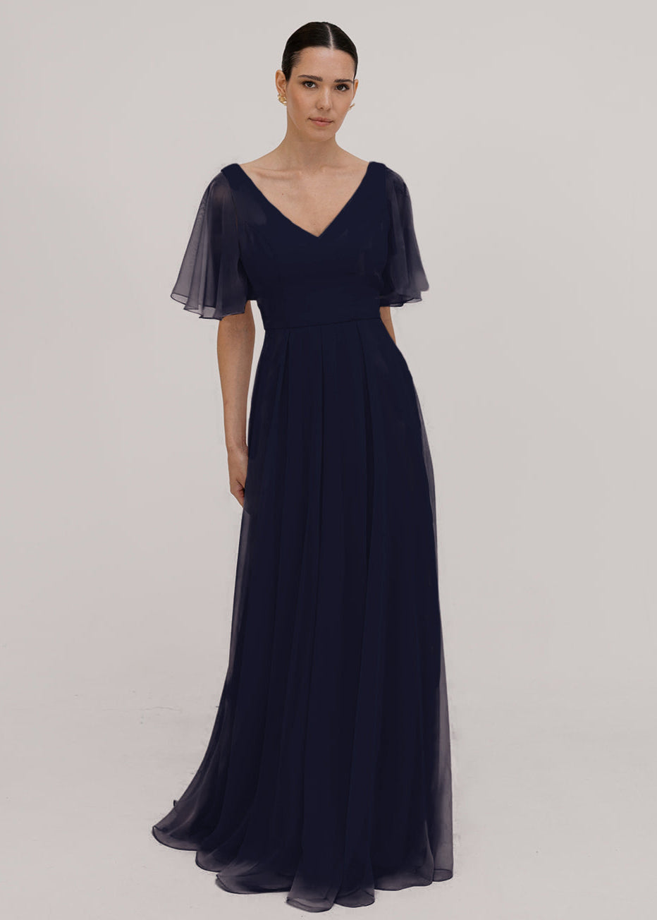 Woman wearing a long navy bridesmaid dress with angel sleeves and V neck in chiffon.
