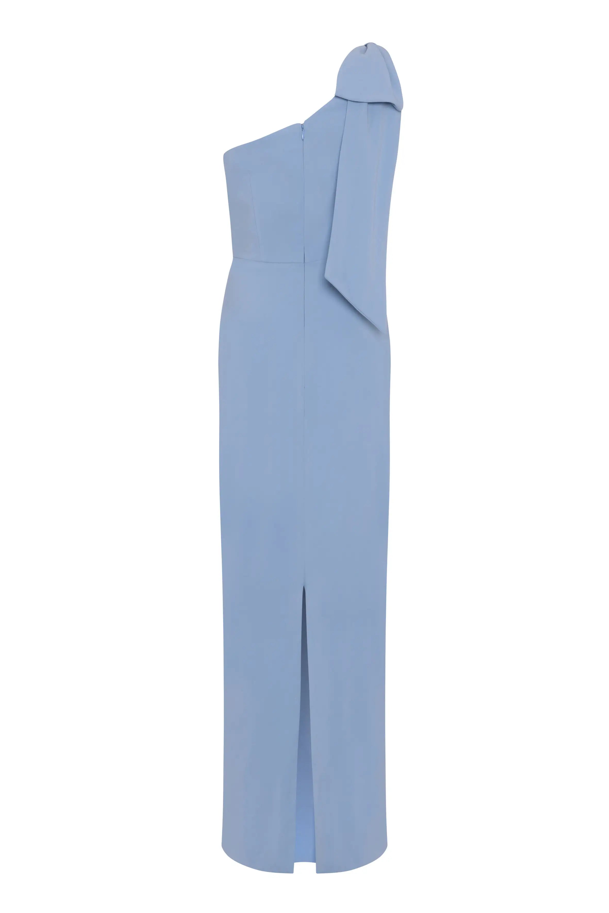 The Valentina Bridesmaid Dress in Dusty Blue by TH&TH is a size-inclusive, modern crepe gown with a floor-length one-shoulder silhouette, fitted bodice, draped sleeve detail, and front slit—ideal for bridal parties.