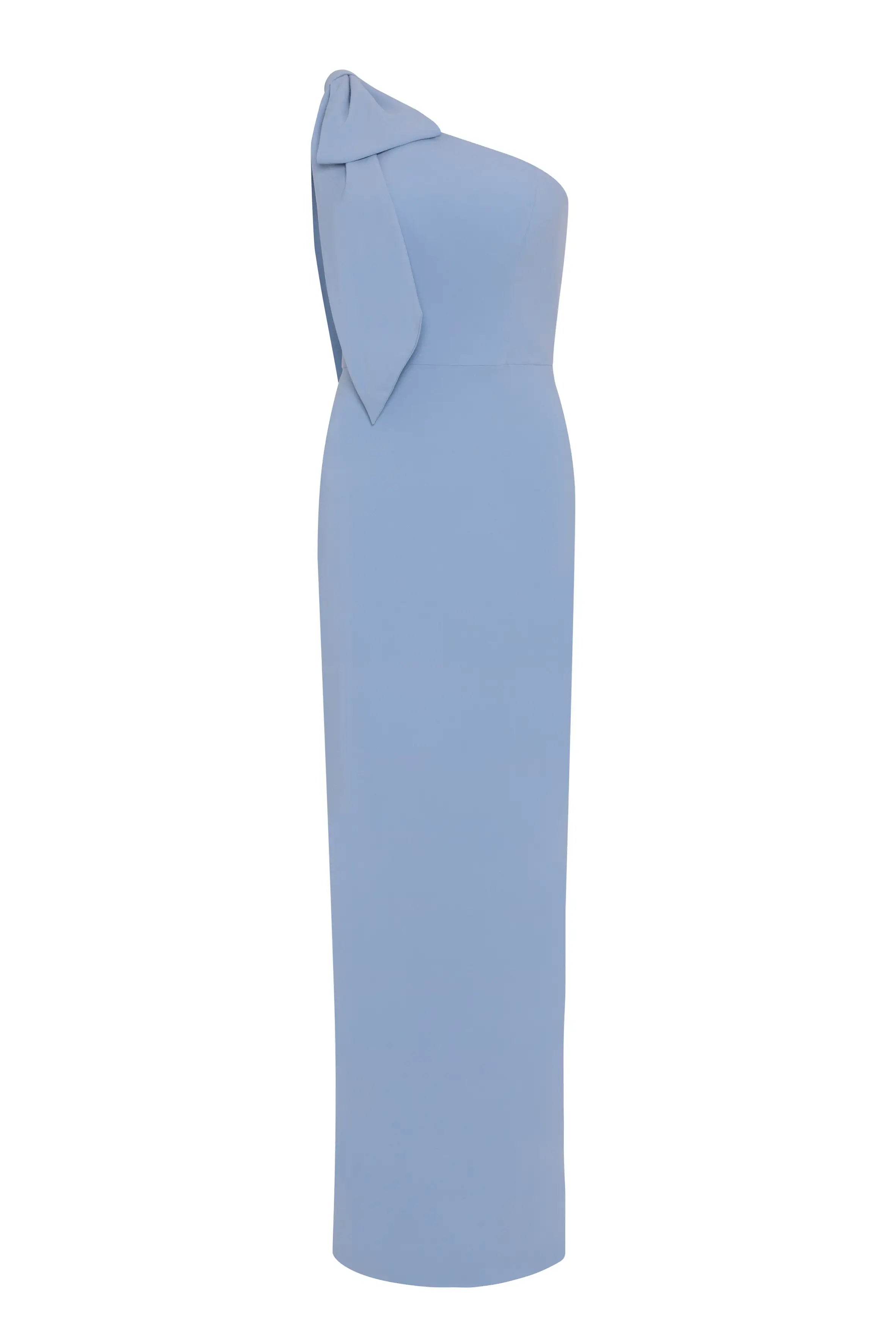 The Valentina Bridesmaid Dress in Dusty Blue by TH&TH is a floor-length, one-shoulder crepe gown with a fitted silhouette and a statement bow—ideal for a modern bridal party.