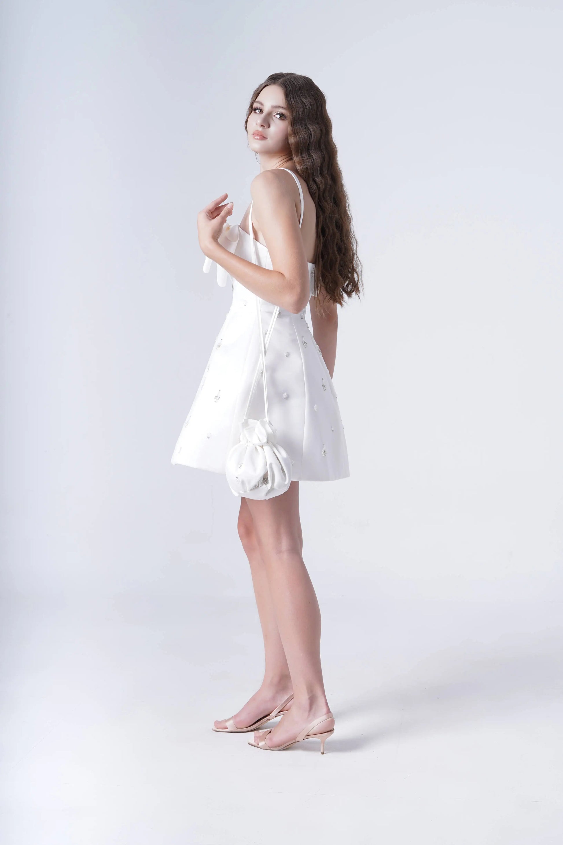 Woman wearing a white dress against a plain background