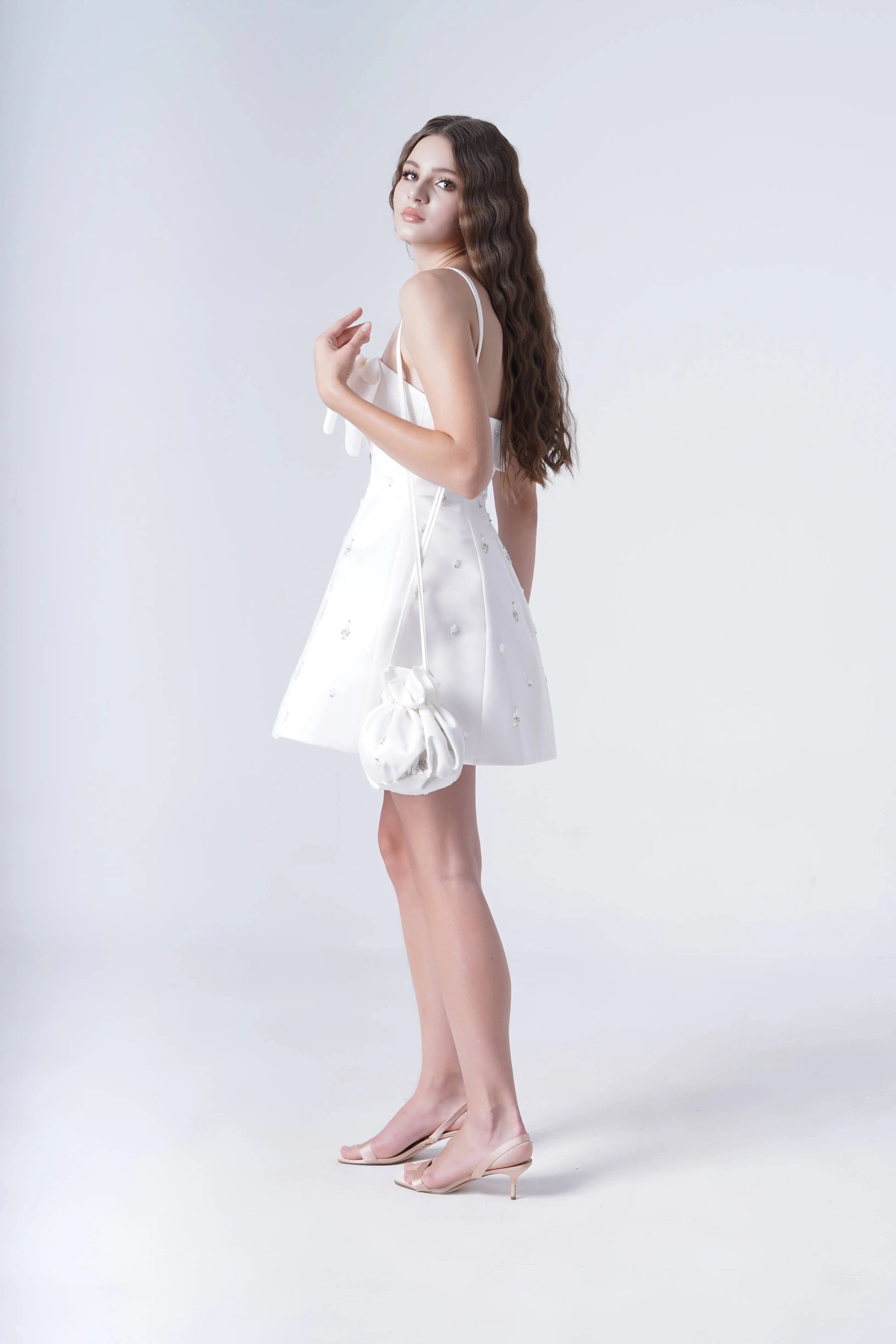 Woman wearing a white dress against a plain background