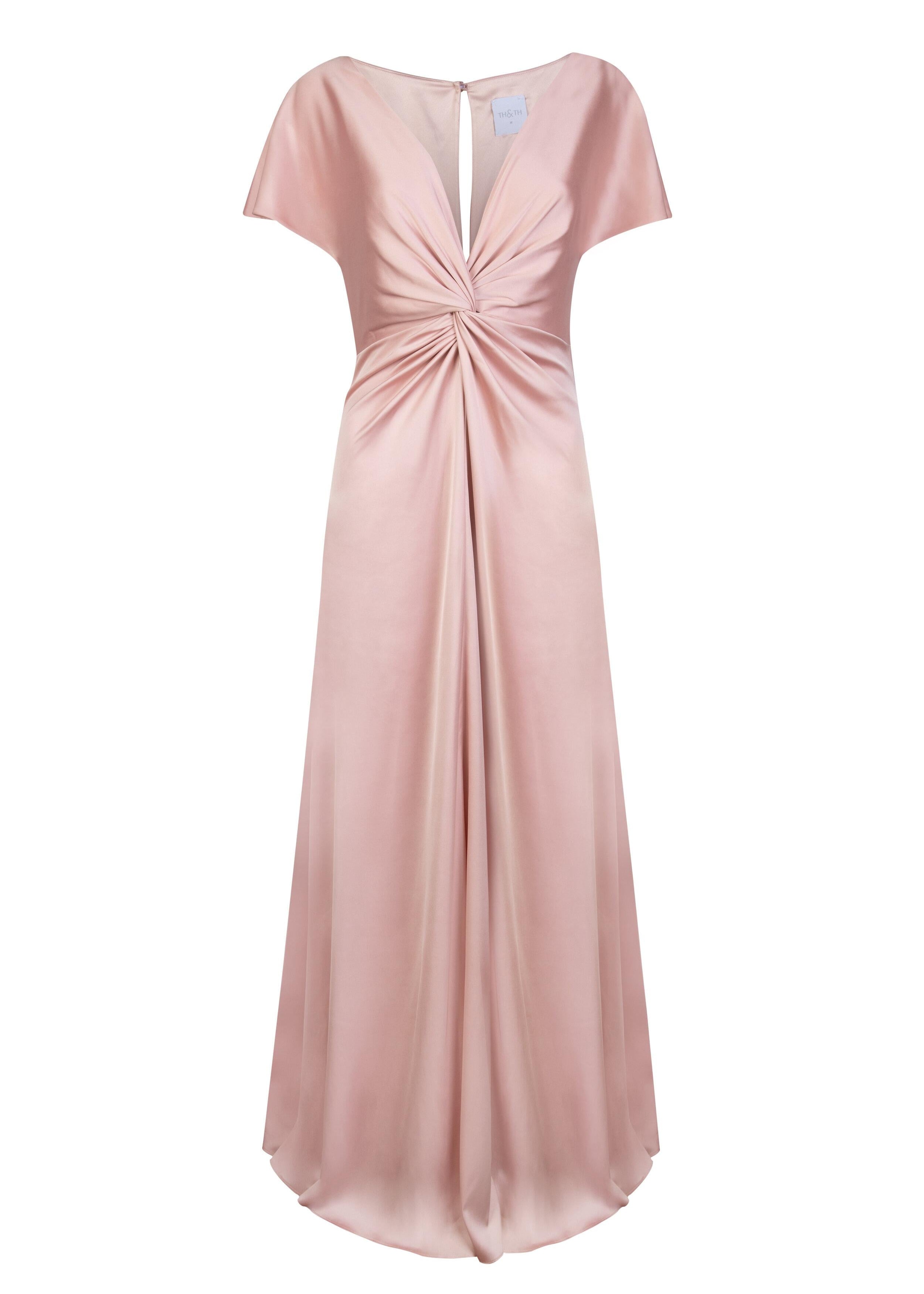A blush pink satin bridesmaid dress with v twist front neckline, flutter sleeves on a white background by TH&TH Bridesmaids. 

